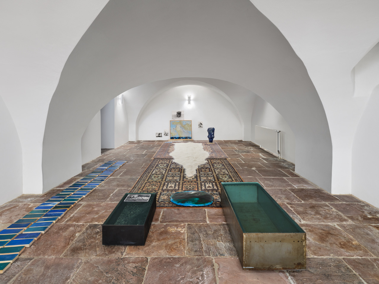 Installation 2026 Egyptian Tongue 2026, Quarz-Sand, Ceramics, Photography, iron/glass Boxes, The Middle East Map, Carpets, 2,40 x 9 x 4,5 m Photo Tobias Hübel
