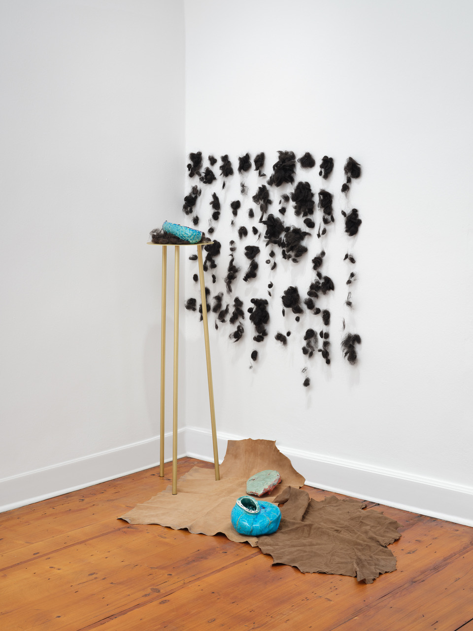 installation 2026 Die Stelle II Dirty Hair, Ceramics, three leg Table of brass, Leather Skins Photo Tobias Hübel